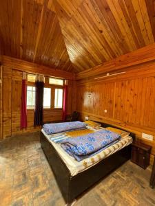 um quarto com uma cama num quarto de madeira em Kiran Home Stay em Shoja