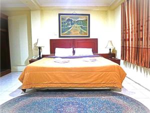 スラバヤにあるD'Hans Hotelのベッドルーム1室(大型ベッド1台、オレンジの毛布付)
