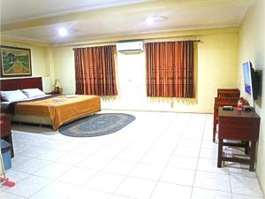 um quarto com uma cama e uma secretária num quarto em D'Hans Hotel em Surabaya