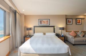 a bedroom with a large bed and a couch at Hyatt Regency Galleria Residence Dubai in Dubai
