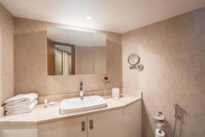 a bathroom with a sink and a mirror at Hyatt Regency Galleria Residence Dubai in Dubai