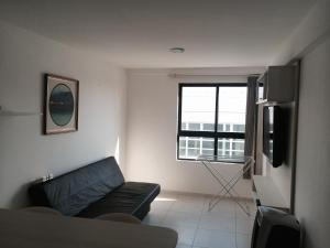sala de estar con sofá y ventana en Apartamento Tambaú, en João Pessoa