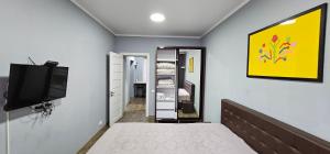 1 dormitorio con 1 cama y TV en la pared en Central Park Apartment, en Chişinău