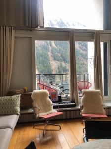 een woonkamer met 2 stoelen voor een groot raam bij Design loft in Chamonix Center in Chamonix-Mont-Blanc