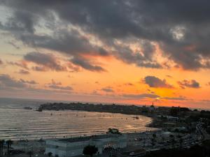 a sunset over a beach with a city and the ocean at Sea View in Acre