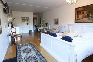 - une chambre avec un lit blanc et un salon dans l'établissement Schellerup Gård, à Herning