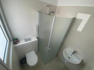 a bathroom with a shower and a toilet and a sink at Sea View in Acre
