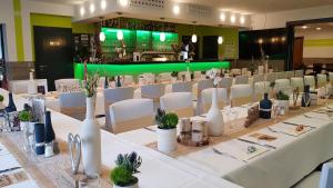 a long table with white tables and white chairs at Bergschänke & Berghotel in Bresinchen