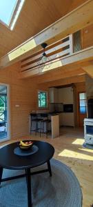 un soggiorno con tavolo e cucina di Domek letniskowy Nad Mrowinkiem a Rybakowo