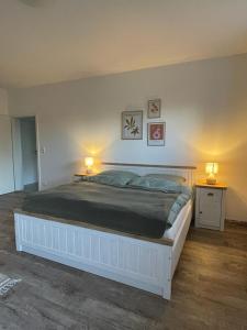 a bedroom with a large white bed with two lamps at Ferienwohnung AllerStall in Buchholz Aller