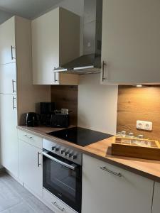 a kitchen with white cabinets and a stove top oven at Ferienwohnung AllerStall in Buchholz Aller