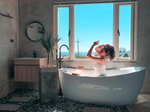 a little girl sitting in a bath tub in a bathroom at Third Sister B&B in Xiaoliuqiu