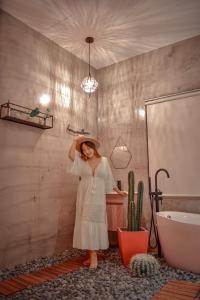 a woman in a white dress standing in a bathroom at Third Sister B&B in Xiaoliuqiu