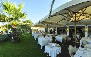 a restaurant with white tables and chairs and umbrellas at Loft Deluxe centralissimo-Antica Vetreria in San Benedetto del Tronto