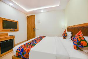 a bedroom with a bed and a flat screen tv at FabHotel Royal Residency I in New Delhi