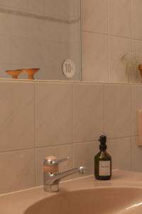 a bottle of soap sitting on a bathroom sink at Casa Rosa in Arisdorf