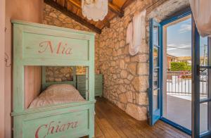a bedroom with a bunk bed in front of a stone wall at Villa Pinia with pool in Pinezici +31 photos