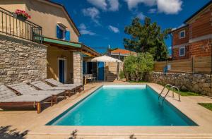a pool in a backyard with lounge chairs and a building at Villa Pinia with pool in Pinezici