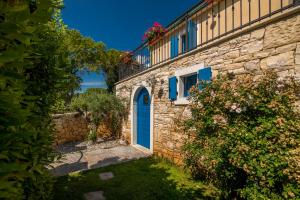 Casa de piedra con puerta azul y ventana en Villa Pinia with pool, en Pinezici