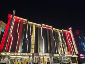 Airport Hotel Ramhan Palace Mahipalpur في نيودلهي: مبنى الفندق عليه انوار حمراء وصفراء