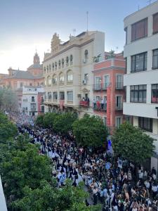 Une grande foule de gens debout dans une rue dans l'établissement Apartamentos Sevilla Centro, à Séville
