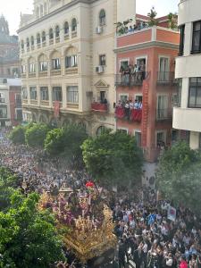 Una grande folla di persone che si trovano davanti a una parata di Apartamentos Sevilla Centro a Siviglia