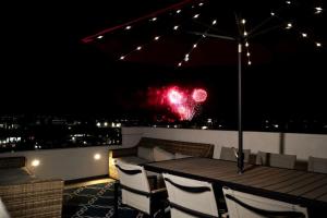 a table and chairs on a balcony at night at Modern comfort, prime location, 360 views, 4 BR entire house in San Diego