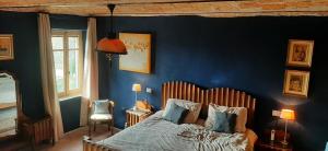 BIAMICI - casa de vacanze in Mombercelli في Mombercelli: غرفة نوم بسرير وجدار ازرق