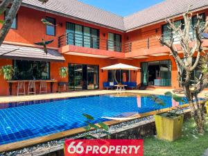 a hotel with a swimming pool in front of a building at THE ONE VILLA in Chiang Mai