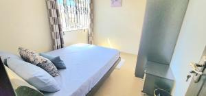 a small room with a bed and a window at Number 7, 2nd floor, Pebble Bay Apartments with Garden View in Grand Baie