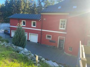een rood huis met een oprit ervoor bij Ferienwohnung Parkblick in Bad Elster