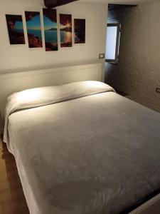 un letto bianco in una camera da letto con immagini appese al muro di IGIEA APARTMENT a Palermo