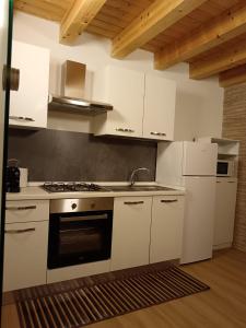 una cucina con mobili bianchi e un forno a piano cottura di IGIEA APARTMENT a Palermo