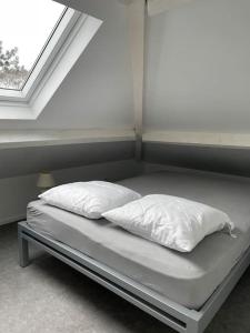 a bed with two pillows on it in a room with a window at Villa Les Hauts de Heusy in Verviers