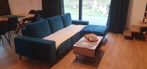 a living room with a blue couch and a table at Willa ViWaldi Janowa Góra in Sienna