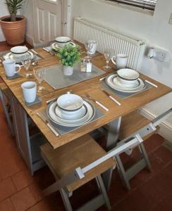 a wooden table with plates and utensils on it at West Street House in Crewe