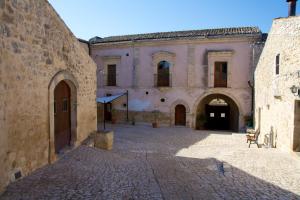 un edificio antiguo con un patio de piedra en una ciudad en Relais Cimillà B&B en Ragusa