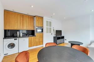 a kitchen with a table and a dining room at One-Bedroom Abode With A Balcony In Central London in London