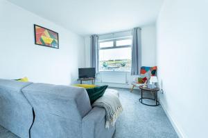 - un salon avec un canapé bleu et une fenêtre dans l'établissement Bliss: Spacious Beach Home, à Dymchurch