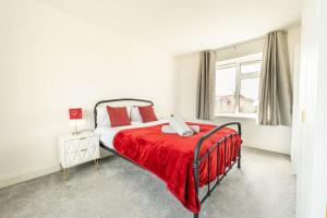 - une chambre avec un lit et une couverture rouge dans l'établissement Bliss: Spacious Beach Home, à Dymchurch