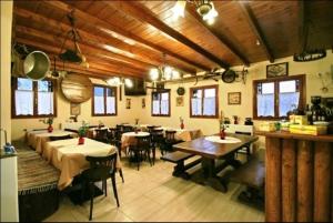 Koustenis Village في ديميتسانا: غرفة كبيرة مع طاولات وكراسي في مطعم