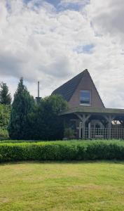 Stickhausen的住宿－Achims Huus 55178，草坪上带 ⁇ 顶的房子