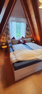 een bed in een kamer met een raam bij Achims Huus 55178 in Stickhausen