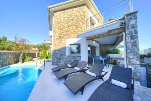 a villa with a swimming pool and patio furniture at Villa Miracle 2 with heated pool in Krk