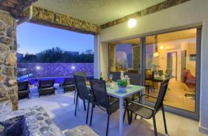 a dining room with a table and chairs on a patio at Villa Miracle 2 with heated pool in Krk