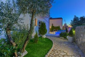 a villa with a garden and a swimming pool at night at Villa Miracle 2 with heated pool in Krk
