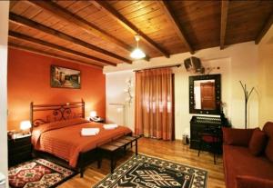 1 dormitorio con 1 cama y sala de estar con piano en Koustenis Village, en Dhimitsana