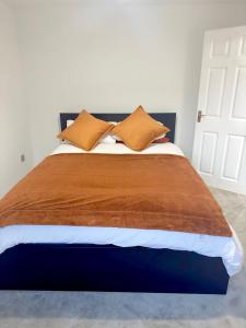 a bedroom with a large bed with orange pillows at Swanmore in Derby