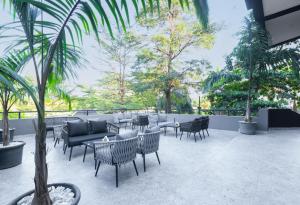 a patio with tables and chairs and trees at Tree House Boutique Hotel in Abuja