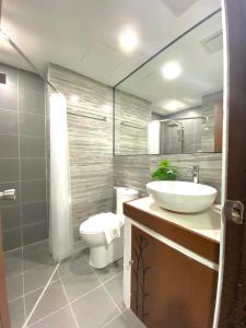 ein Badezimmer mit einem weißen Waschbecken und einem WC in der Unterkunft Bloom Boracay in Boracay